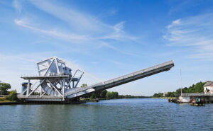 The modern replacement for the famous Pegasus Bridge in Normandy, France. The bridge crosses the Caen canal that runs between Caen and Ouistreham. Also known as Benouville bridge. The bridge is a rolling bascule design, sometimes referred to as a drawbridge.
